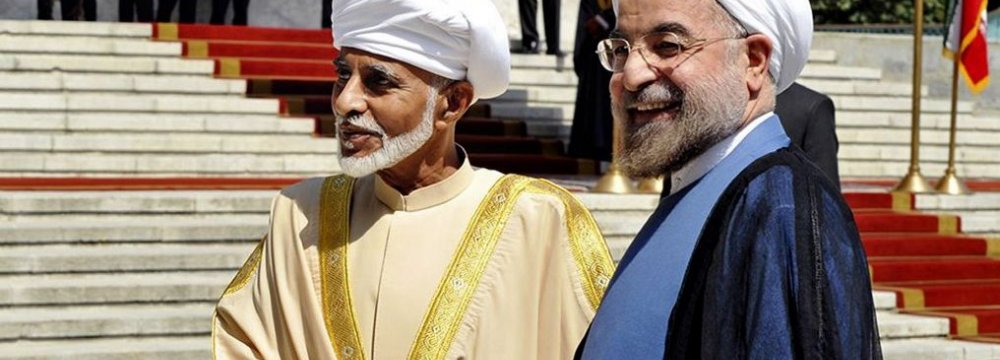 President Hassan Rouhani (R) greets Oman’s Sultan Qaboos bin Said at the presidential palace in Tehran on August 25, 2013.