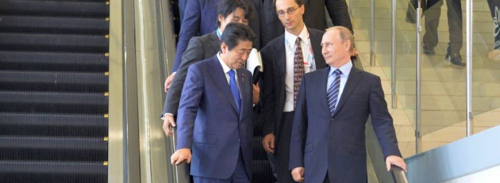 Prime Minister Shinzo Abe (L) and Russian President Vladimir Putin ride down an escalator during their meeting on the sidelines of the Eastern Economic Forum in Vladivostok, Russia, on Sept. 2. 