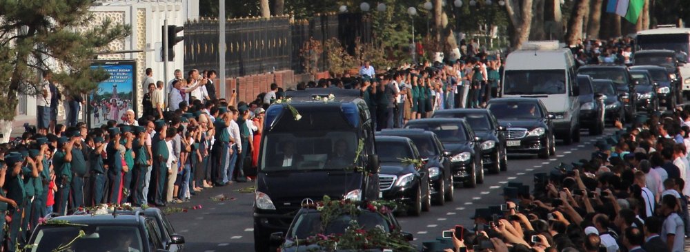 People pay tribute to the late Uzbek president, Islam Karimov, as the funeral motorcade passes along a road in Tashkent on Sept. 3. 