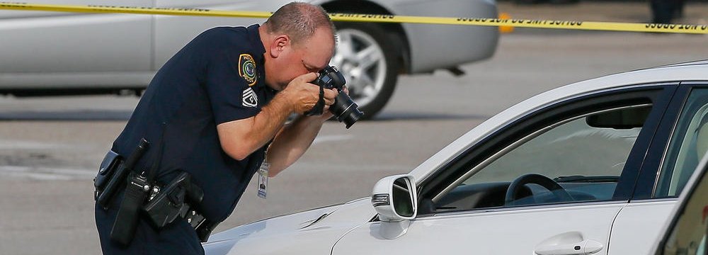 A police investigator photographs a vehicle with gunshot damage in Houston, Texas, USA, on Sept. 26.