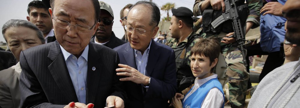 WB President Jim Yong Kim (C), accompanied UN Secretary-General Ban Ki-moon at an informal Syrian refugee camp in Tripoli, Lebanon, in March. Kim says he wants to turn the World Bank into a more agile and efficient banking group.