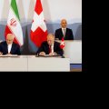 President Hassan Rouhani (top- L) and President Alain Berset (top-R) watch as Foreign Minister Mohammad Javad Zarif (L) and Swiss Economic Minister Johann Schneider-Ammann sign an agreement in Bern on July 3.
