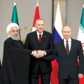 Hassan Rouhani (L), Turkey’s Recep Tayyip Erdogan (C) and Vladimir Putin of Russia lock hands while posing for photos at the start of a summit on Syria in Ankara on April 4. 