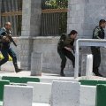 Security forces take up positions around the parliament's premises in Tehran on June 7 to fight IS terrorists holed up in one of the buildings.  
