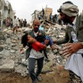 A man carries a five-year-old child rescued from the site of a Saudi-led airstrike that killed eight of her  family members in Sanaa, Yemen, August 25.