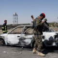 Afghan security forces inspect the exterior of a car after a suicide bomb blast in Paktia Province, Afghanistan, on June 18.