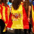 Youths wrapped in a Catalan, a Spanish and an Estelada (Catalan separatist) flag walk through a street during a protest two days after the independence referendum in Barcelona on October 3.