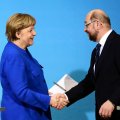 Angela Merkel (L) shakes hands with SPD leader Martin Schulz.