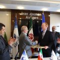 CEO of Iran Aseman Airlines Hossein Alayi (L) shakes hands with James Larson, regional director for contracts at Boeing, in Tehran on March 18.