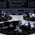 Traders in front of the German share price index, DAX board, at the stock exchange in Frankfurt. 