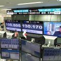 A television screen (top R) displays file news footage of North Korean leader Kim Jong-Un, at a foreign exchange brokerage in Tokyo on August 29, after the North fired a missile over northern Japan.