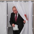 Presidential candidate, President Vladimir Putin, walks out of a voting booth at a polling station during Russia’s presidential election in Moscow on March 18. (Photo: AFP)