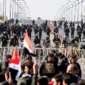Riot police stand in front of demonstrators during the protest near Baghdad’s Green Zone on Feb. 11.