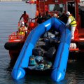 Migrants intercepted aboard a dinghy off the coast  in the Mediterranean Sea help rescuers unload their dinghy from a rescue boat after arriving at the port  of Malaga, southern Spain, on July 7.