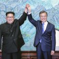 North Korean leader Kim Jong-un (L) and South Korean President Moon Jae-in hold hands at the border village  of Panmunjom in the Demilitarized Zone, South Korea, on April 27.
