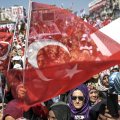 People cheer and wave the national flag as Turkey’s president delivers a speech during a rally on the eve of the constitutional referendum, on April 15 in Istanbul.